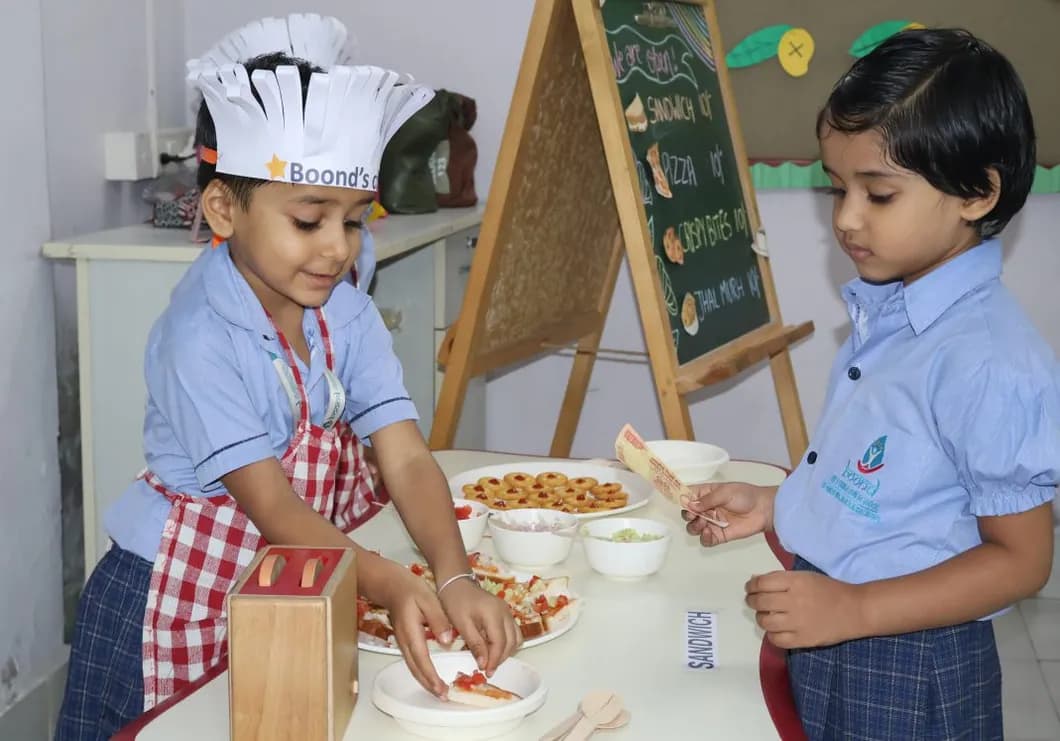 Two children in chef hats preparing a snack