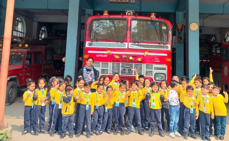 A class visiting a fire station and posing in front of the engine